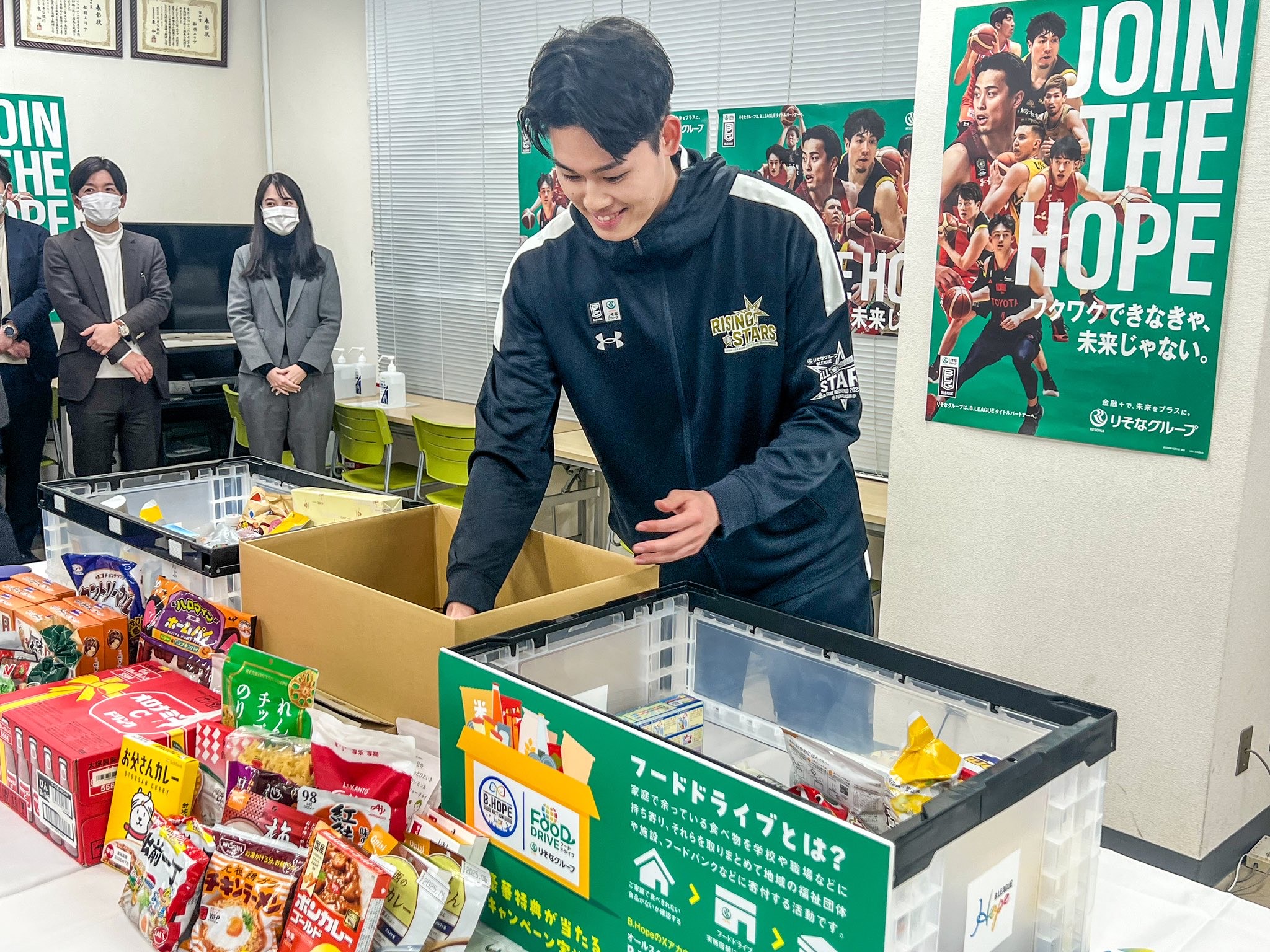 金近廉選手がフードドライブで集まった食品の仕分けをしている写真