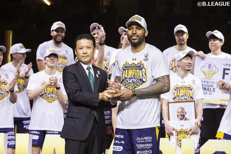 Bリーグ2024-25シーズンファイナルで、りそなホールディングス南社長が宇都宮ブレックスのD.J・ニュービル選手にMVPを贈呈している写真