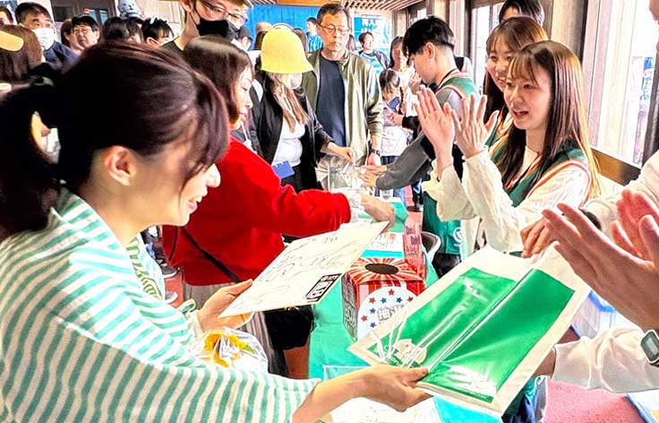 りそなグループのブースで来場者に景品を手渡す様子