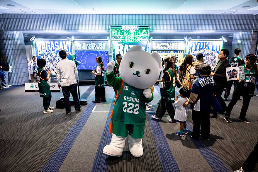 Bリーグのユニフォームを着た「りそにゃ」がりそなグループのブースの前でポーズをしている