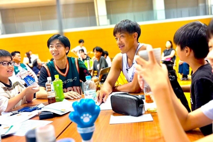 京都会場で選手と子ども達が人生やりくりゲームをしている写真