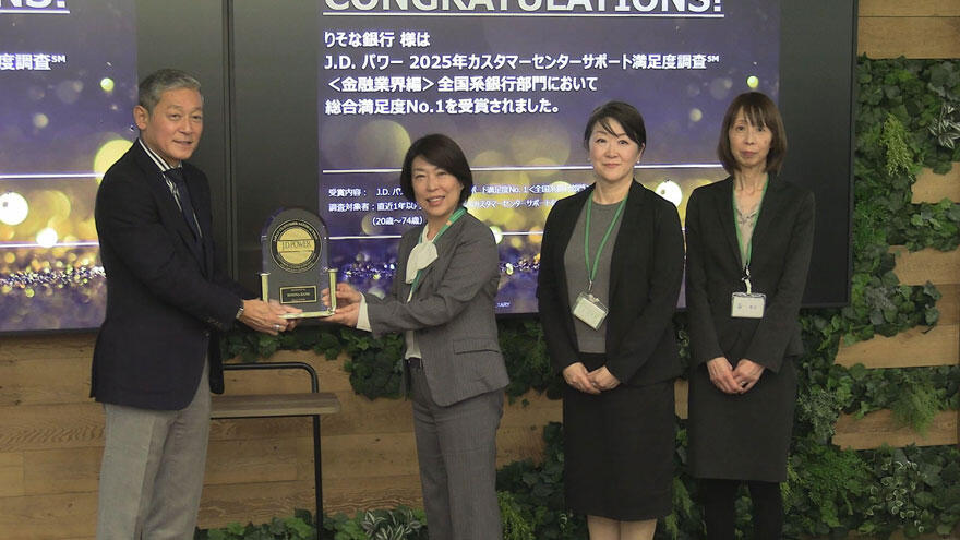 「全国系銀行部門第1位」の盾を笑顔で受け取っている様子