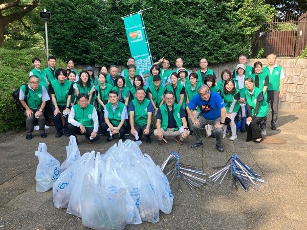 集めたゴミと一緒に記念写真を撮る従業員