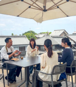 シェフと学生計4名が、商品開発に向け、テーブルを囲み対話や意見交換を行っている様子